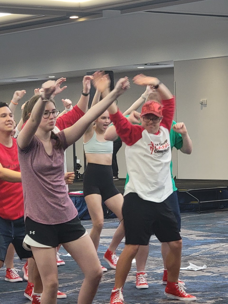 Borderless Arts TN dancers rehearse dancers in athletic gear doing coordinated dance moves during rehearsal.