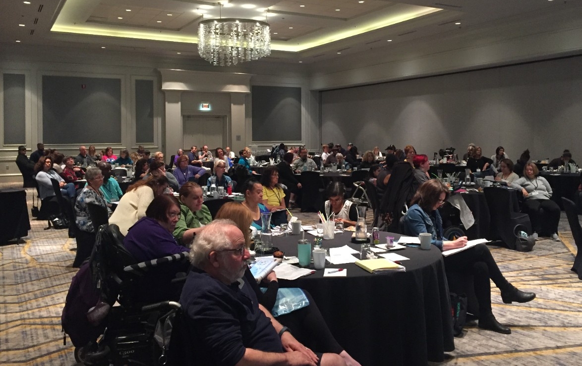 large crowd of seated people, adults with and without disabilities, attending the Council's 2018 partners in policymaking reunion
