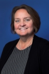 headshot of Lynette Porter, a white woman with short brown hair, a striped blouse and black cardigan