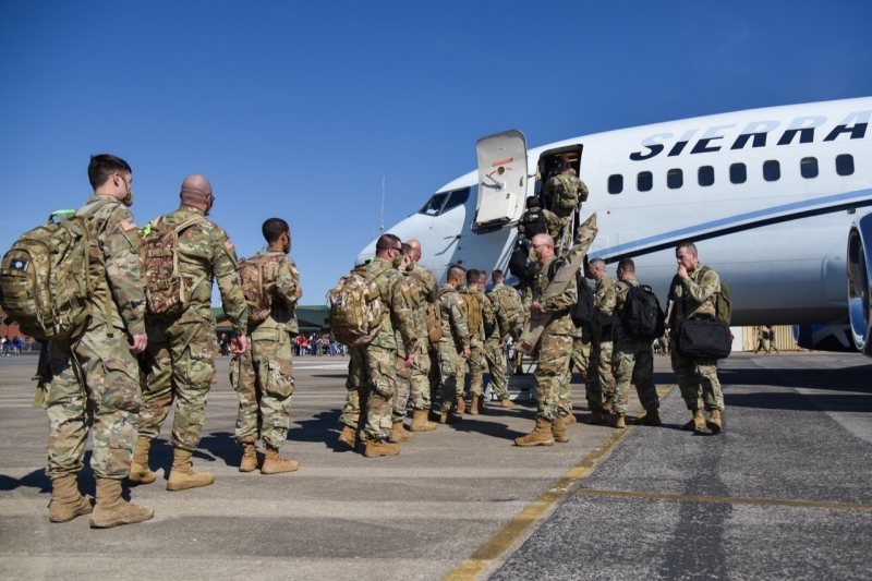 Soldiers boarding a plane on a runway