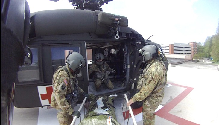 The Tennessee National Guard’s Col. Robert Ross (left), Staff Sgt. Donald Sweet (center), and Sgt. 1st Class Giovanni DeZuani (right) offload a stroke patient at the University of Tennessee Medical Center helipad in Knoxville after a search and rescue mission along the Appalachian Trail, April 15. (Courtesy Photo from the Tennessee National Guard) Tennessee National Guard Helicopter and crew