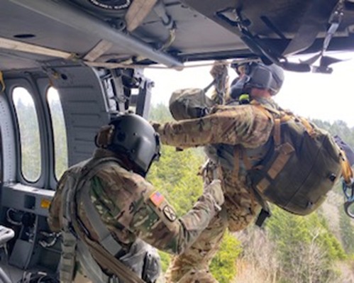 Staff Sgt. Donald Sweet begins hoist operations and lowers Sgt. 1st Class Tracy Banta to the patient at the Double Springs Gap Shelter on the Appalachian Trail, April 15. (Courtesy Photo from the Tennessee National Guard) Guard members using hoist on helicopter