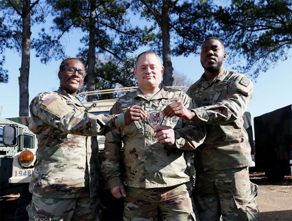 Spc. Daija Brunson, Sgt. 1st Class Jonathan Jones, and Spc. Christopher Williams hold a Shelby County Sheriff’s Office patch at the Millington National Guard Armory, Jan. 8. All three Soldiers are full-time deputies with the Shelby County Sheriff’s Office and members of the Tennessee National Guard’s 268th Military Police Company, based in Millington. They are three of more than 80 Soldiers who left Jan. 10, for a yearlong deployment to the Horn of Africa in support of U.S. Africa Command. (photo by Staff Sgt. Mathieu Perry) Spc. Daija Brunson, Sgt. 1st Class Jonathan Jones, and Spc. Christopher Williams hold a Shelby County Sheriff’s Office patch at the Millington National Guard Armory, Jan. 8. All three Soldiers are full-time deputies with the Shelby County Sheriff’s Office and members of the Tennessee National Guard’s 268th Military Police Company, based in Millington. They are three of more than 80 Soldiers who left Jan. 10, for a yearlong deployment to the Horn of Africa in support of U.S. Africa Command. (photo by Staff Sgt. Mathieu Perry)