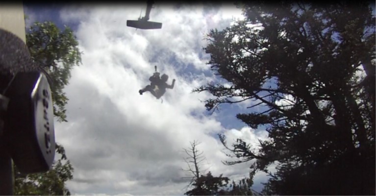 Tennessee National Guard crew chief, Staff Sgt. Ryan McKnight, lowers the flight paramedic, Sgt. 1st Class Nolan Ogle, to a sick hiker during a rescue at the Great Smoky Mountains National Park, August 15. (Submitted photo)